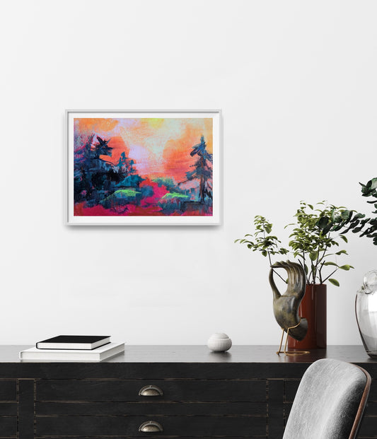 Framed abstract painting on a wall, bright colors, above a desk.